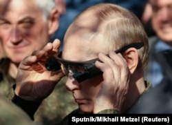 Президент России Владимир Путин надевает тепловизионные очки во время встречи с военнослужащими и осмотра оборудования для наблюдения за совместными российско-белорусскими военными учениями "Запад-2025" на полигоне Мулино в Нижегородской области, Россия, 16 сентября 2025 года